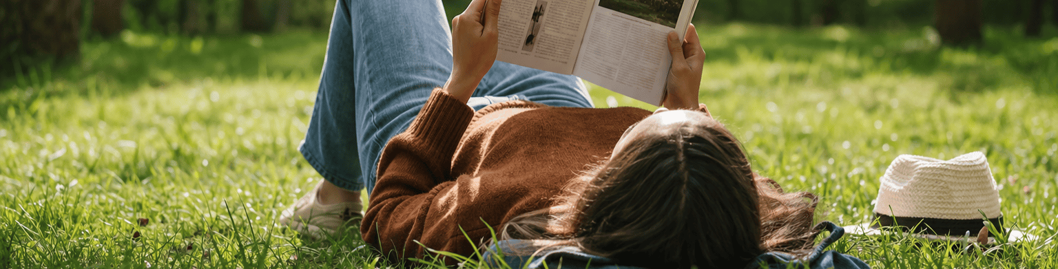 Vrouw leest een boek op het gras