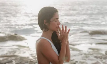 Vrouw die mediteert aan zee