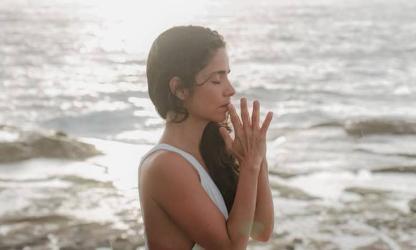 Vrouw die mediteert aan zee