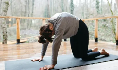Vrouw die kat koe yogaoefeningen doet